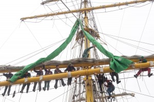 Mitglieder der ehrenamtlichen Crew sind ins Rigg aufgeentert, um die neuen grünen Segel anzunähen.